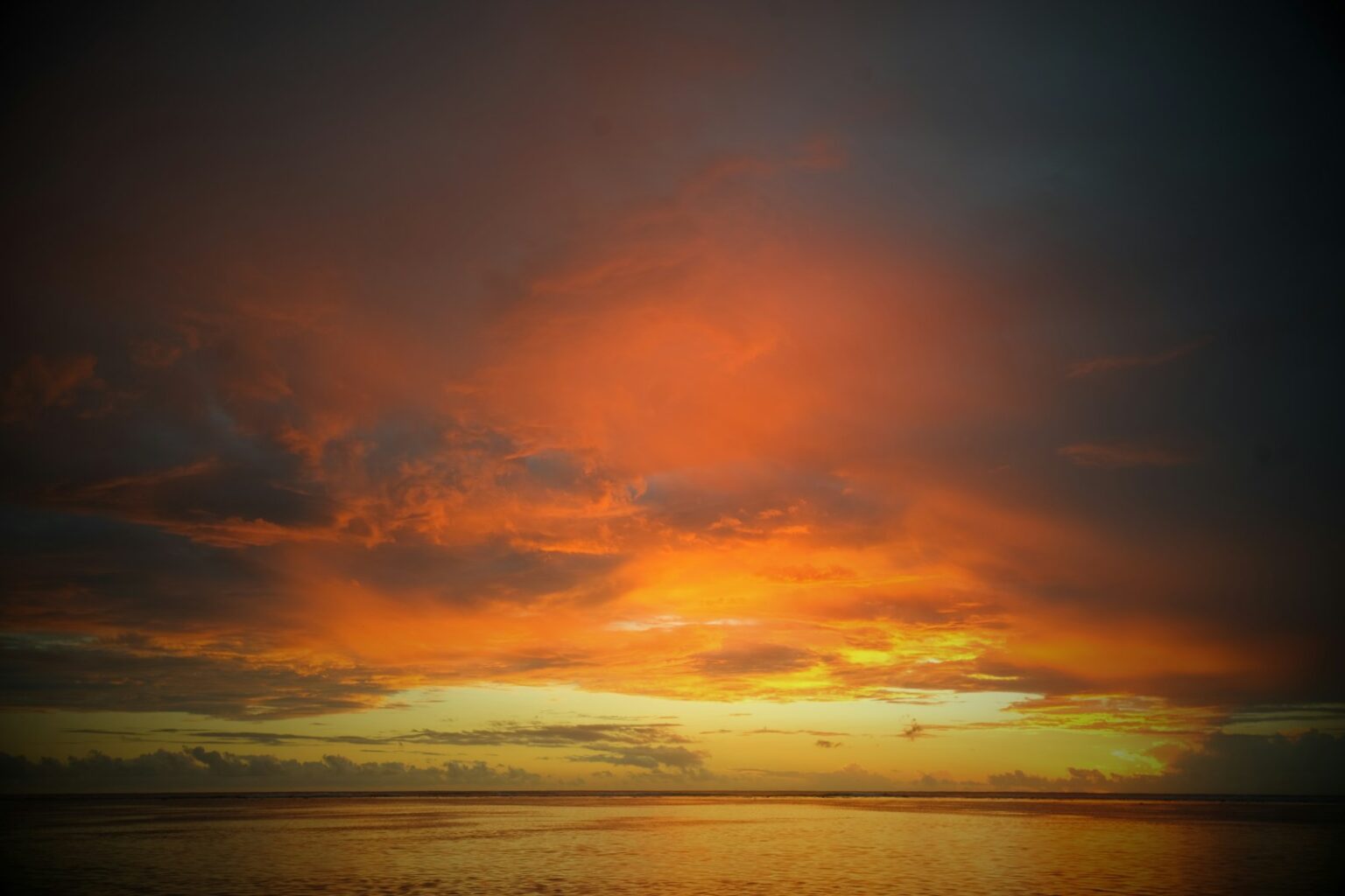 body of water under orange and gray sky