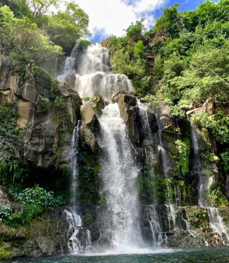 waterfalls in the middle of the forest during daytime